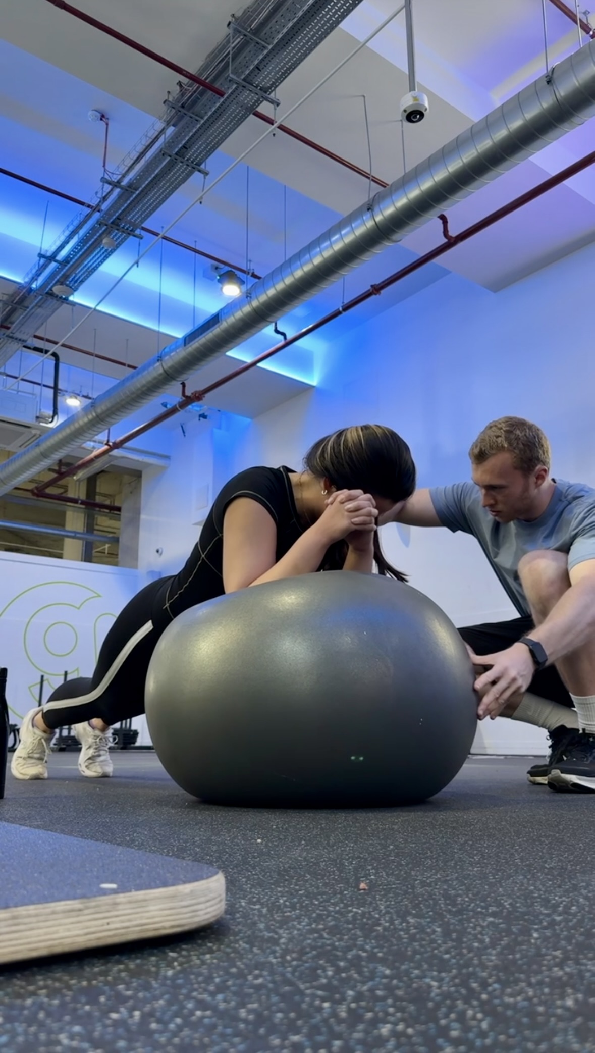Brady coaching a client through a stability ball exercise